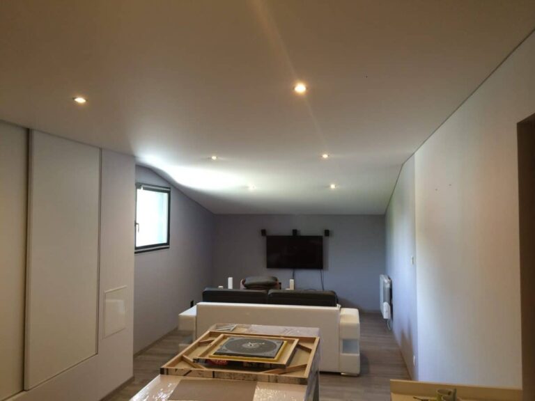 Plafond tendu en PVC brillant dans un salon moderne avec éclairage intégré