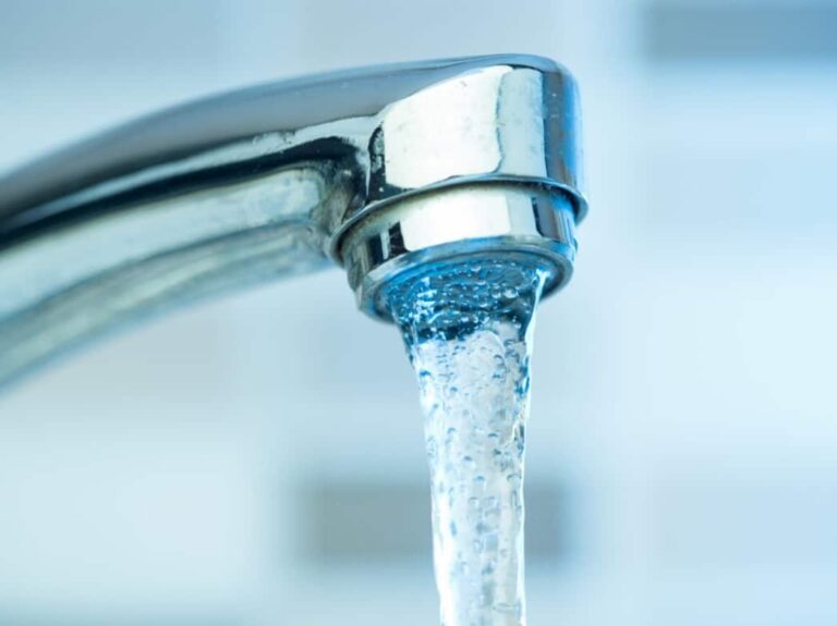 Eau claire s'écoulant d'un robinet en cuisine