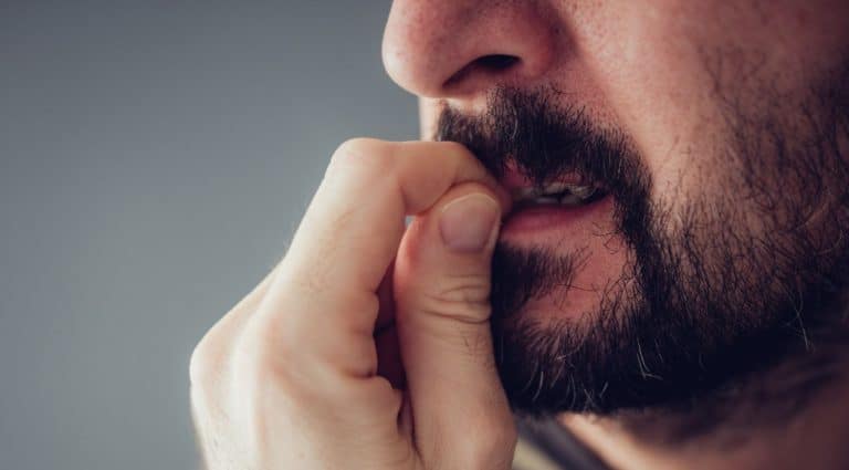 Un homme se ronge les ongles