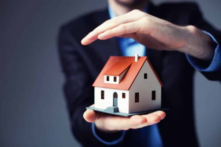 Contrat d'assurance habitation avec des clés et une maison en arrière-plan