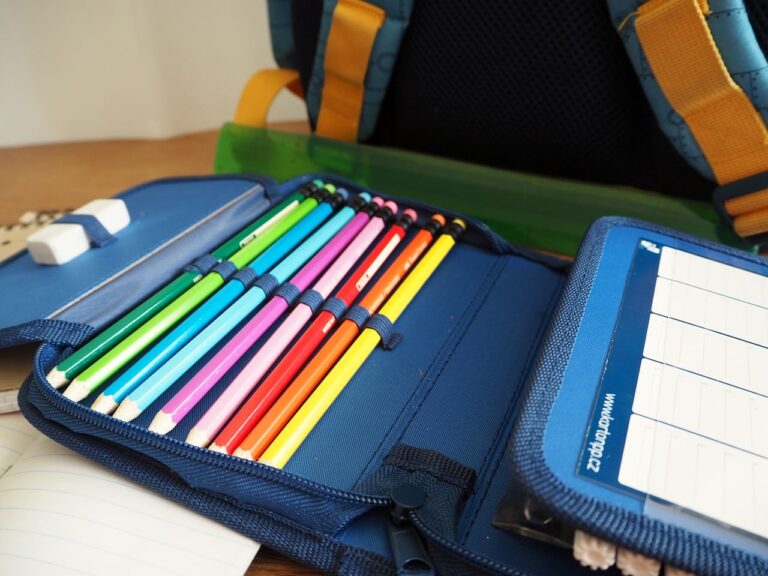 Trousse scolaire ouverte avec crayons, stylos et surligneurs colorés