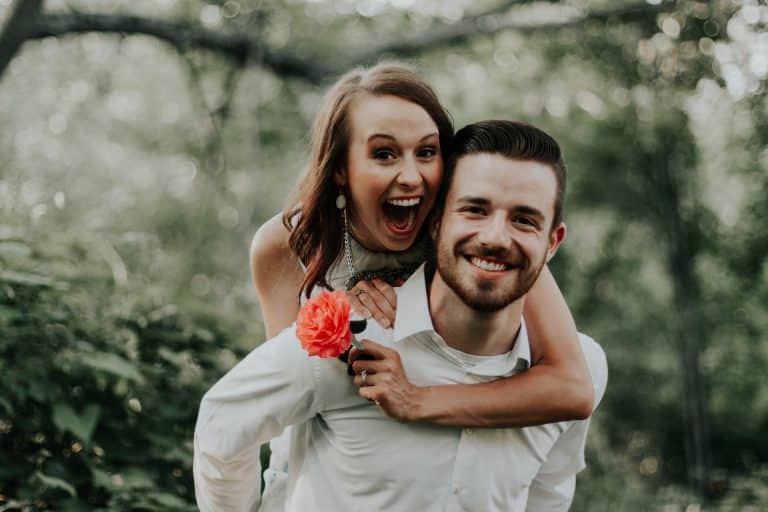 Un couple souriant partageant un moment complice dans un parc
