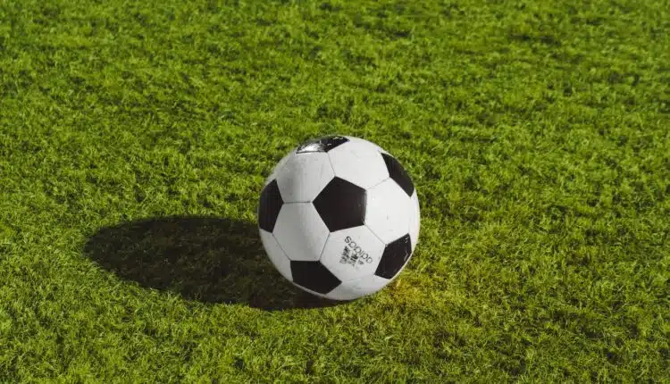 white and black soccer ball on grass field