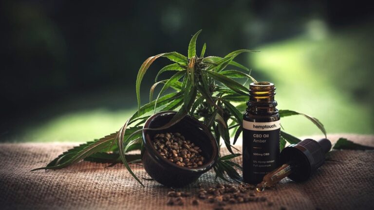 Huiles de CBD sur une table avec des plantes vertes