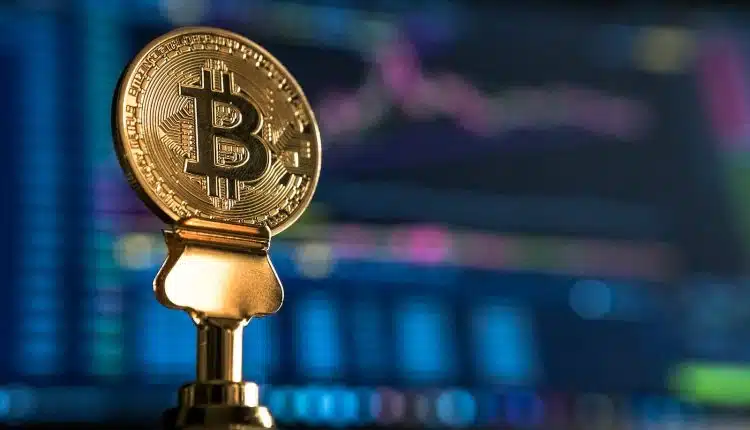 selective focus photo of Bitcoin near monitor