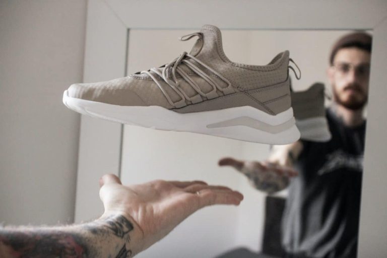 Baskets tendance posées sur un sol en bois avec des douleurs aux pieds